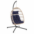 Fauteuil suspendu en rotin synthétique avec coussins bleus, structure en acier